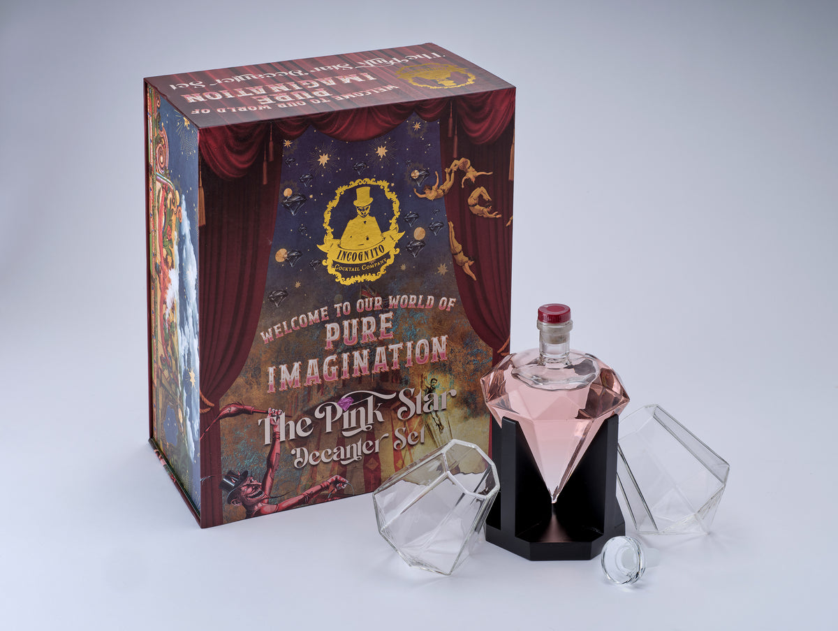 Incognito Pink Star luxury decanter gift set with diamond-shaped decanter and two diamond glasses, presented in a premium illustrated gift box with luxury gift bag.
